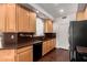 Bright kitchen with wood cabinets, dark countertops, hardwood floors and stainless appliances at 6510 S Hazelton Ln # 101, Tempe, AZ 85283