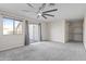 This bedroom features carpet flooring, a ceiling fan, a closet with shelving, and a sliding glass door at 6623 S 23Rd Dr, Phoenix, AZ 85041