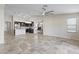 Open-concept living space combining kitchen and living room with stylish travertine flooring at 6623 S 23Rd Dr, Phoenix, AZ 85041