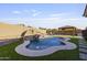 Beautiful backyard pool featuring a rock waterfall and a covered seating area, perfect for outdoor relaxation at 6623 S 23Rd Dr, Phoenix, AZ 85041