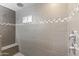 Modern shower with gray tiling, a built-in bench, and decorative glass blocks at 6623 S 23Rd Dr, Phoenix, AZ 85041