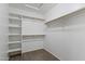 Bright, empty walk-in closet with built-in shelving and a carpeted floor at 6623 S 23Rd Dr, Phoenix, AZ 85041