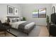 A cozy bedroom features a queen bed, natural light from the window, and chic decor for a tranquil space at 6935 W Monte Lindo St, Glendale, AZ 85310