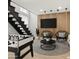 A modern living area offers stylish hanging chairs, wall-mounted TV and nearby staircase, perfect for modern living and entertaining at 6935 W Monte Lindo St, Glendale, AZ 85310