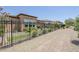 Well-manicured backyard featuring a black iron fence, lush landscaping, and convenient access to a community walking path at 699 E Watermelon Ln, Queen Creek, AZ 85140