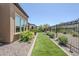 A tidy side yard with artificial turf and desert landscaping enclosed by a wrought iron fence at 699 E Watermelon Ln, Queen Creek, AZ 85140