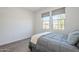 Light-filled bedroom with two windows, neutral decor, and wood-look flooring at 699 E Watermelon Ln, Queen Creek, AZ 85140