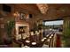 Elegant dining room with fireplace, chandelier, and outdoor views of the golf course at 699 E Watermelon Ln, Queen Creek, AZ 85140