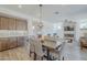 Open dining room space with wood table adjacent to the kitchen with ample lighting at 699 E Watermelon Ln, Queen Creek, AZ 85140
