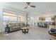 Bright living room featuring a ceiling fan, large windows, and an open floor plan at 699 E Watermelon Ln, Queen Creek, AZ 85140