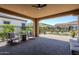 Covered patio featuring brick pavers, ceiling fan, fire pit and seating area at 699 E Watermelon Ln, Queen Creek, AZ 85140
