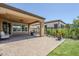 Covered outdoor patio featuring sleek pavers, black iron fence, and a comfortable seating area, perfect for entertaining at 699 E Watermelon Ln, Queen Creek, AZ 85140