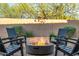 Charming outdoor patio area with a fire pit, seating, and attractive landscaping for relaxing evenings at 7152 E Night Glow Cir, Scottsdale, AZ 85266