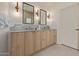 Bright bathroom with a double sink vanity featuring wood cabinets, a marble countertop, and stylish light fixtures at 7152 E Night Glow Cir, Scottsdale, AZ 85266