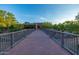 Scenic bridge leading to the clubhouse with lush desert landscaping and vibrant architectural design at 7152 E Night Glow Cir, Scottsdale, AZ 85266