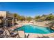 Beautiful community pool area with lounge chairs and shaded seating, surrounded by desert landscaping at 7152 E Night Glow Cir, Scottsdale, AZ 85266