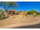 Desert home with three-car garage featuring drought resistant landscaping at 7152 E Night Glow Cir, Scottsdale, AZ 85266
