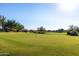 Scenic view of a well-manicured green golf course with surrounding desert landscape and clear blue sky at 7152 E Night Glow Cir, Scottsdale, AZ 85266