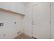 Functional laundry room with white cabinetry, a wooden shelf, and sleek white walls at 7152 E Night Glow Cir, Scottsdale, AZ 85266