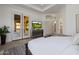 Comfortable main bedroom with a golf view, French doors, a TV, and a glimpse into the en-suite bathroom at 7152 E Night Glow Cir, Scottsdale, AZ 85266
