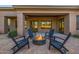 Beautiful outdoor patio features a cozy fire pit surrounded by comfortable seating with access to the home's interior at 7152 E Night Glow Cir, Scottsdale, AZ 85266