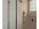Modern shower stall features a rain shower head, handheld sprayer, tiled walls, and a glass block window at 7152 E Night Glow Cir, Scottsdale, AZ 85266