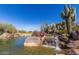 Scenic water feature with cascading waterfalls, desert plants, and native rocks at 7152 E Night Glow Cir, Scottsdale, AZ 85266
