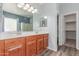 Bathroom featuring a double vanity, large mirrors, and wood-look flooring at 7169 W Lamar Rd, Glendale, AZ 85303