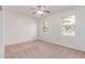 Secondary bedroom with carpet, two windows, and a ceiling fan at 7169 W Lamar Rd, Glendale, AZ 85303