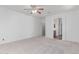 Large main bedroom with neutral carpet, ceiling fan, and ensuite bathroom at 7169 W Lamar Rd, Glendale, AZ 85303