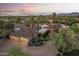 Sprawling home with a three-car garage, desert landscaping and mature palm trees under a colorful sunset at 7640 E Poinsettia Dr, Scottsdale, AZ 85260