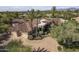 Aerial view of property showcasing circular design, tile roof, desert landscaping, and three-car garage at 7640 E Poinsettia Dr, Scottsdale, AZ 85260
