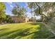 Expansive backyard featuring lush green lawn, mature trees, and a charming covered patio in a private setting at 7640 E Poinsettia Dr, Scottsdale, AZ 85260