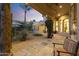 Evening view of the backyard, with a covered patio, desert landscaping, and warm lighting at 7640 E Poinsettia Dr, Scottsdale, AZ 85260
