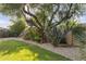 Landscaped backyard featuring mature trees, colorful foliage, and a decorative element adding character to the yard at 7640 E Poinsettia Dr, Scottsdale, AZ 85260