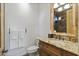 Elegant powder room featuring granite counters and a decorative mirror at 7640 E Poinsettia Dr, Scottsdale, AZ 85260