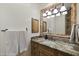 Bathroom with granite countertop, decorative mirror, and tiled backsplash at 7640 E Poinsettia Dr, Scottsdale, AZ 85260