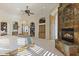 Bedroom with fireplace, built-in shelves, arched window seat, and ceiling fan at 7640 E Poinsettia Dr, Scottsdale, AZ 85260