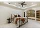 Bedroom with an arched window, built-in shelves and drawers, and neutral decor at 7640 E Poinsettia Dr, Scottsdale, AZ 85260