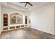 Spacious bedroom with tiled floors, custom built-ins, and a window seat beneath an arched window at 7640 E Poinsettia Dr, Scottsdale, AZ 85260