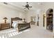 Large bedroom with a ceiling fan, built-in bookcase, and arched window seat at 7640 E Poinsettia Dr, Scottsdale, AZ 85260