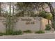 Elegant stone entrance sign for Portales del Sol community, featuring lush landscaping and desert vegetation at 7640 E Poinsettia Dr, Scottsdale, AZ 85260