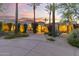 An impressive home entrance featuring a circular drive, mature landscaping, and desert plants at 7640 E Poinsettia Dr, Scottsdale, AZ 85260