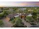 A beautiful home featuring mature palm trees, desert landscaping, and a circular driveway at 7640 E Poinsettia Dr, Scottsdale, AZ 85260