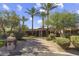 A beautiful home featuring mature palm trees, desert landscaping, and a circular driveway at 7640 E Poinsettia Dr, Scottsdale, AZ 85260