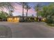 Stunning single-story home features a three-car garage, mature palm trees, and desert landscaping at dusk at 7640 E Poinsettia Dr, Scottsdale, AZ 85260