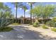 Inviting single-story home with a circular driveway, mature palm trees, and colorful desert landscaping at 7640 E Poinsettia Dr, Scottsdale, AZ 85260
