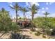 Stunning home exterior showcasing lush landscaping, palm trees, and a private entrance at 7640 E Poinsettia Dr, Scottsdale, AZ 85260