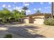 A spacious three-car garage with mature trees, desert landscaping, and a concrete driveway at 7640 E Poinsettia Dr, Scottsdale, AZ 85260