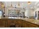 Open concept kitchen island with granite countertop, custom wood cabinets, and adjacent Gathering room at 7640 E Poinsettia Dr, Scottsdale, AZ 85260